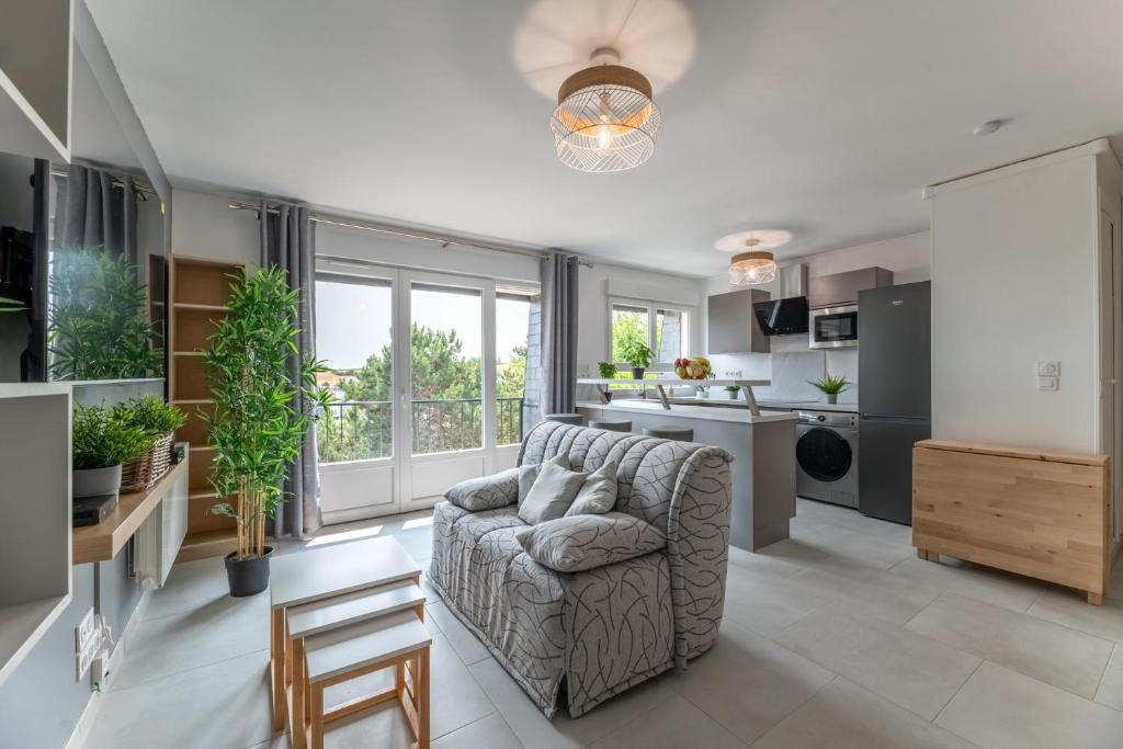ein Wohnzimmer mit einem Sofa und einer Küche in der Unterkunft Appartement 1 pièce très chaleureux in Louviers