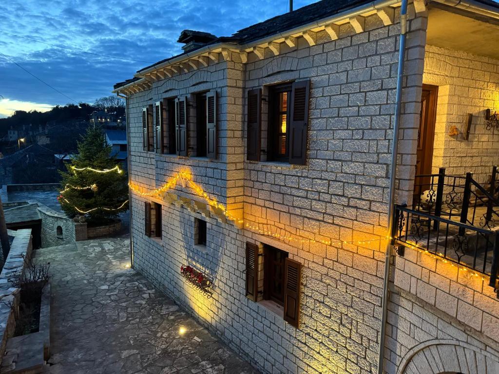 a brick house with lights on the side of it at Βίτσα Πετρόκτιστο Αρχοντικό "Ιόλη" με θέα Ζαγόρι in Vitsa