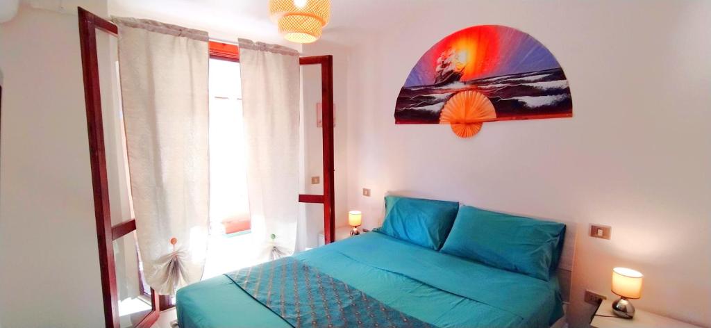 Un dormitorio con una cama azul y una ventana. en Villa Acquamarina Villasimius, en Villasimius