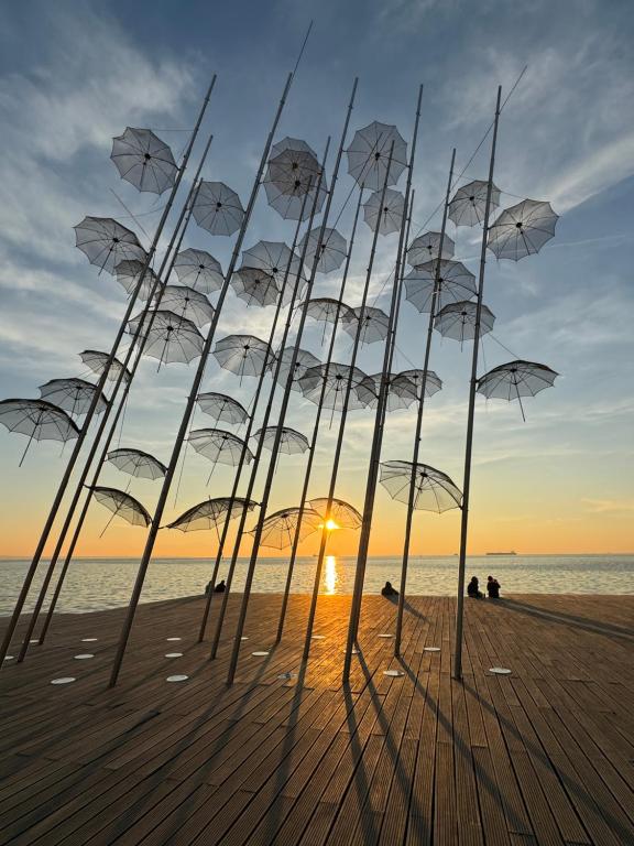 a group of umbrellas on a beach at sunset at Promenade city apartment in Thessaloniki