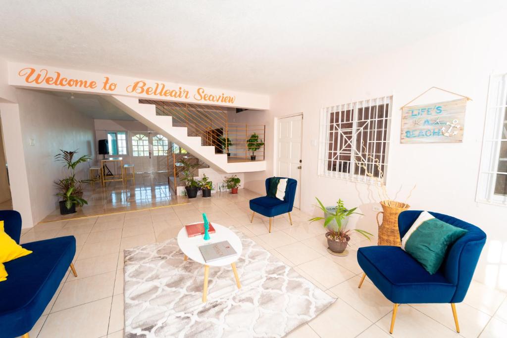 sala de estar con sillas azules y mesa en Bell Air Seaview (3 BDRM 3 BATH), en Runaway Bay