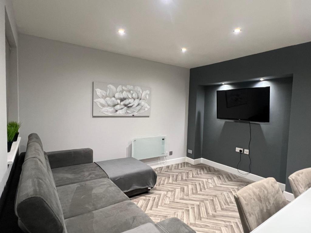 a living room with a couch and a flat screen tv at Broadway Retreat with free parking in Herne Bay