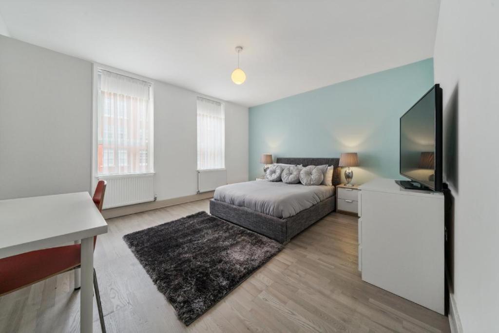 uma sala de estar com um sofá e uma televisão em Modern 3 Bed 2 Bath Apartment London Denmark Hill, Camberwell, Brixton - Perfect For Long Stays em Londres