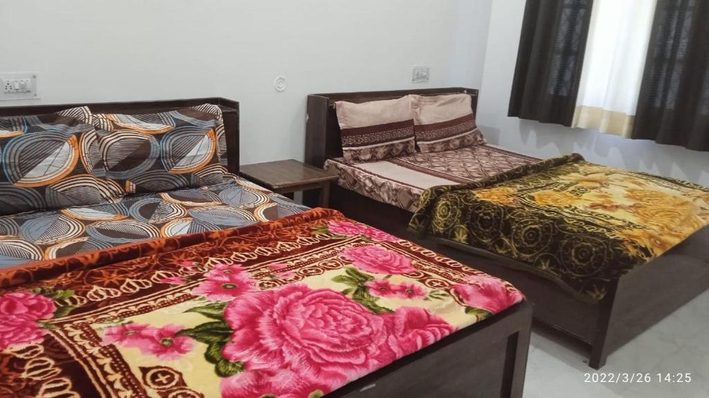 a room with three beds with flowers on them at Utterkashi Prithvi yatra hotels in Uttarkāshi