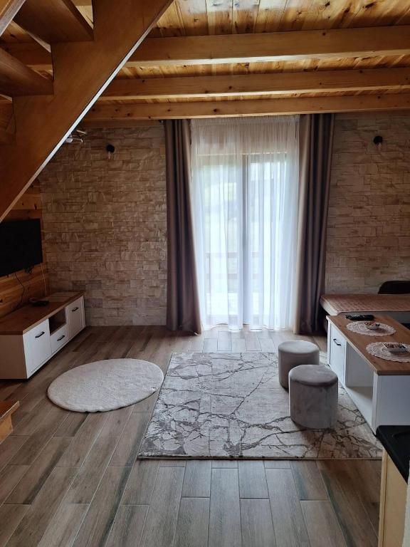 a large living room with a large window and wooden ceilings at House Bojana in Žabljak