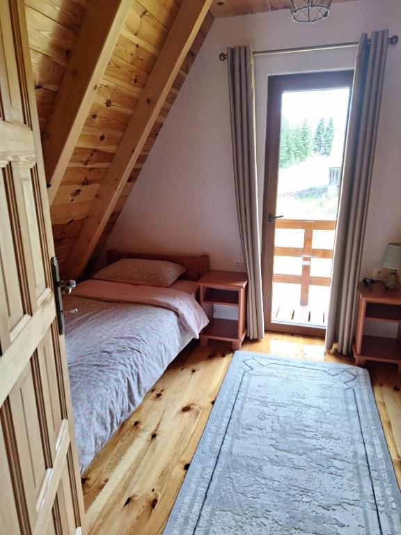 a bedroom with a bed and a large window at House Bojana in Žabljak