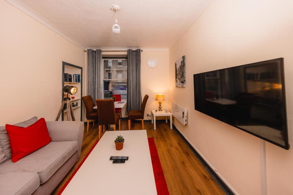 sala de estar con sofá y TV de pantalla plana grande en Cozy Old Town 4 Bedrm Apartment en Edimburgo