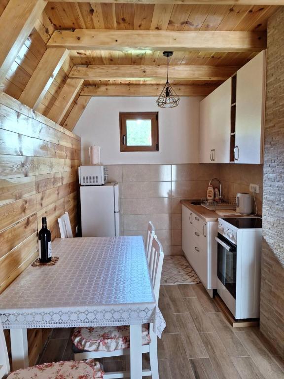 a kitchen with a table and a white table and chairs at House Bojana in Žabljak