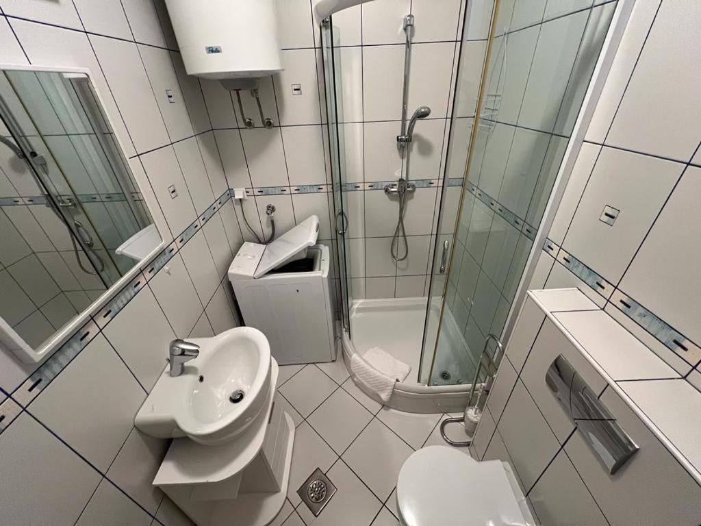 a bathroom with a shower and a sink and a toilet at Sea view & pool studio by Pag tours in Pag