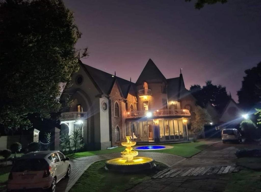a large house with a fountain in front of it at night at Castle Home in Centurion