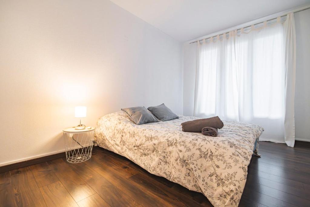 a bedroom with a bed and a lamp on a wooden floor at Joli appartement Le Chalet + parking in Reims
