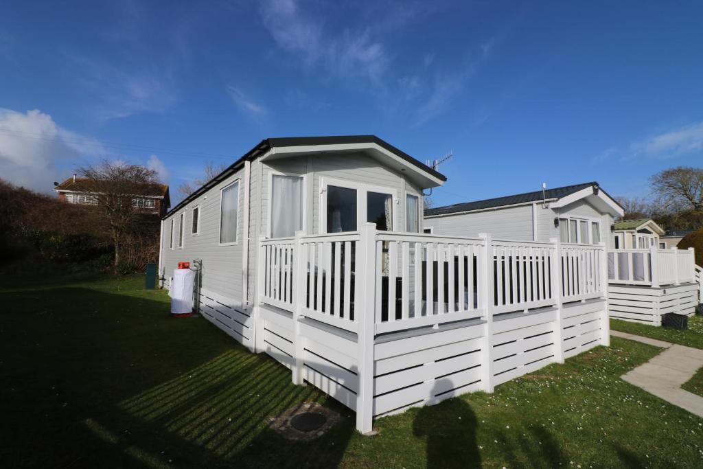 a white house with a porch and a yard at The Willows in Selsey