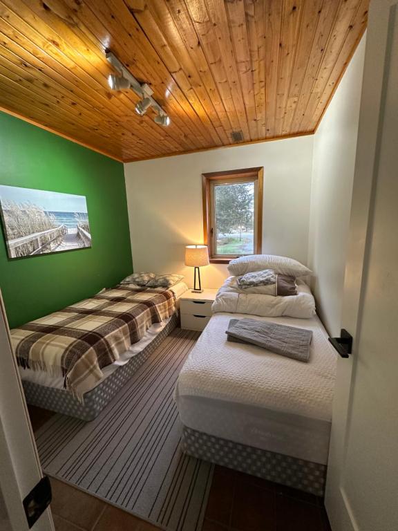 Schlafzimmer mit 3 Betten und Holzdecke in der Unterkunft PEC Waterfront in Hillier
