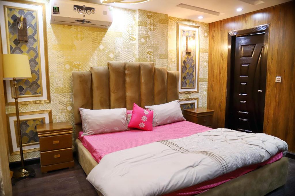 a bedroom with a large bed with pink sheets at Adara in Rāmkot