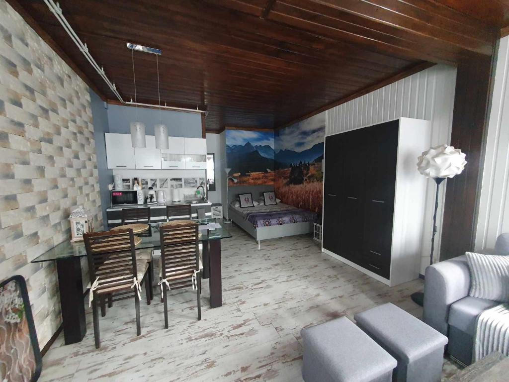 a living room with a table and chairs and a couch at Pod Śnieżynką in Zakopane