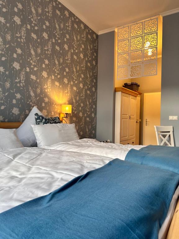 una camera da letto con un grande letto bianco con una coperta blu di Hansestübchen a Wismar