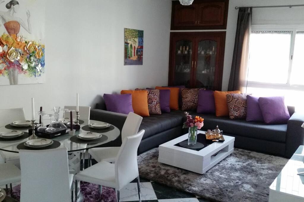 ein Wohnzimmer mit einem Sofa und einem Tisch in der Unterkunft Appartement Tetouan Saniat Ramel Airport Plage Martil WIFI in Tétouan