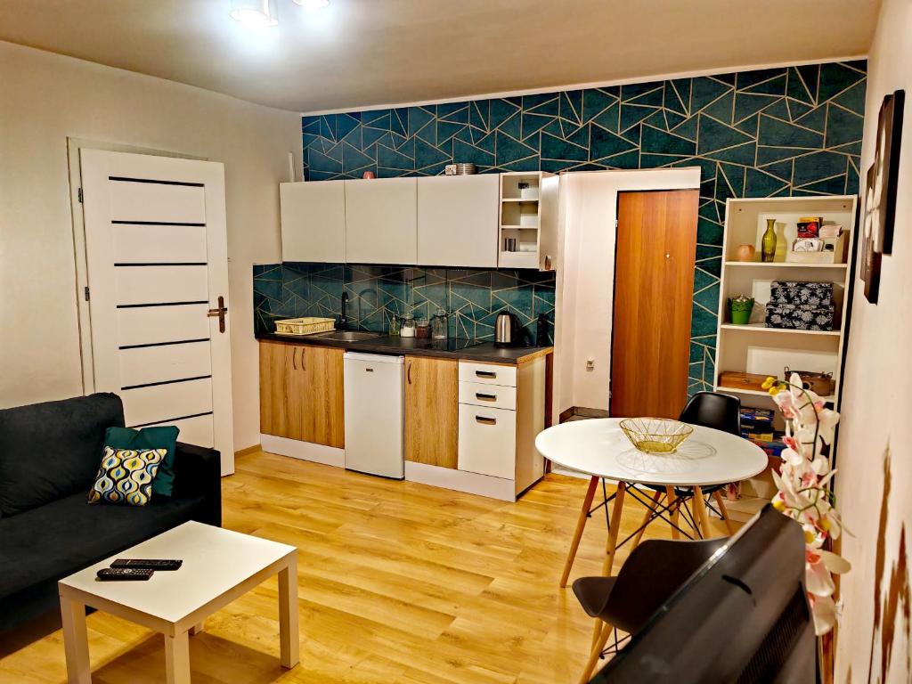 uma pequena sala de estar com uma mesa e uma cozinha em Apartament Chełmsko em Chełmsko Śląskie