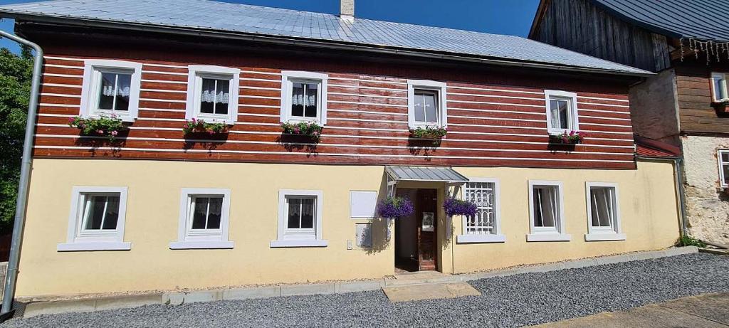 Chalupa u Žižky في Jiřetín pod Jedlovou: منزل خشبي مع علب الزهور على النوافذ