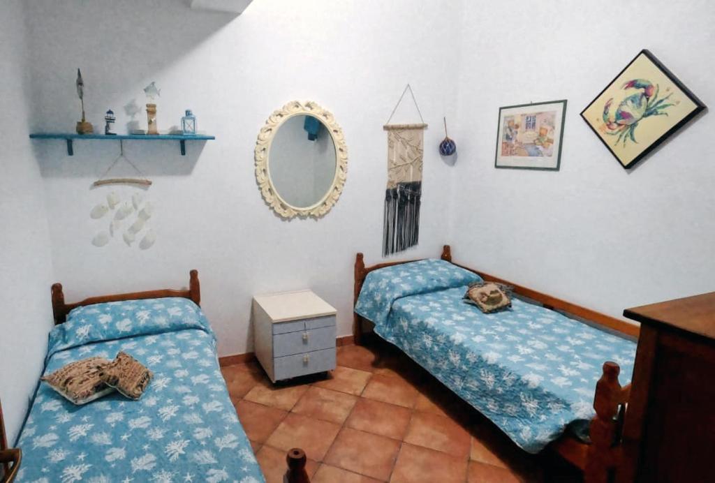 una camera con due letti e uno specchio di Casa Tequi a 200mt dal mare a Terrasini