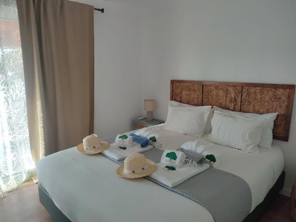 a bedroom with a bed with hats on it at Chão do Ribeirinho 