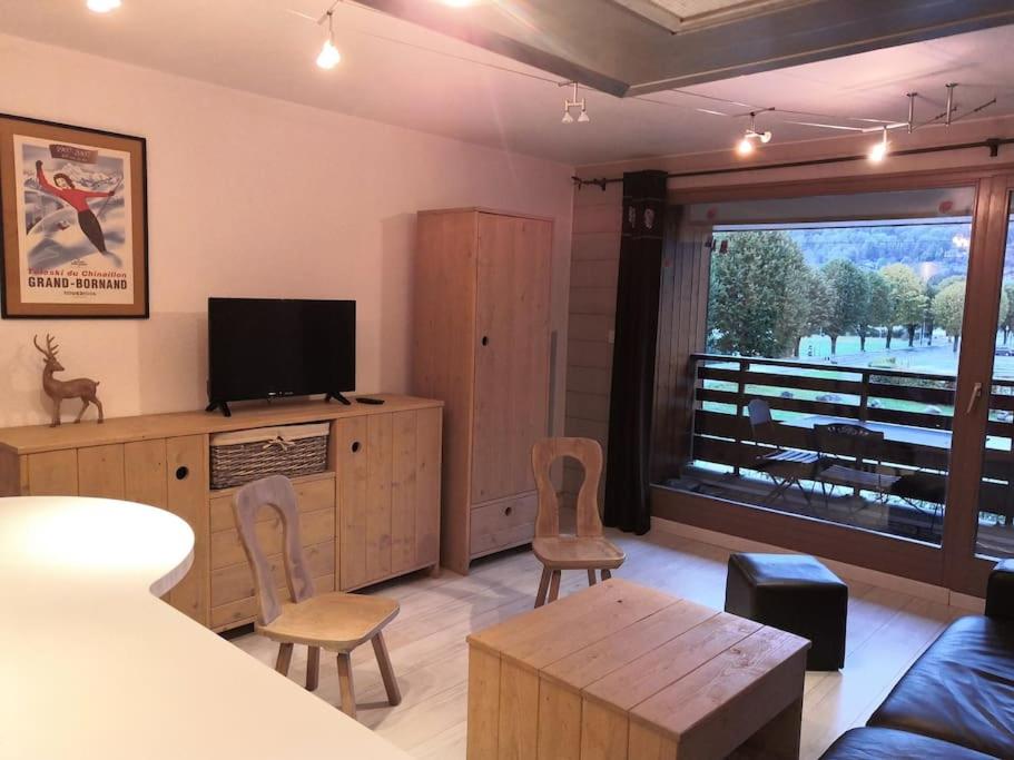 un salon avec une télévision, un canapé et des chaises dans l'établissement Appart 4P face télécabine GME, à Samoëns