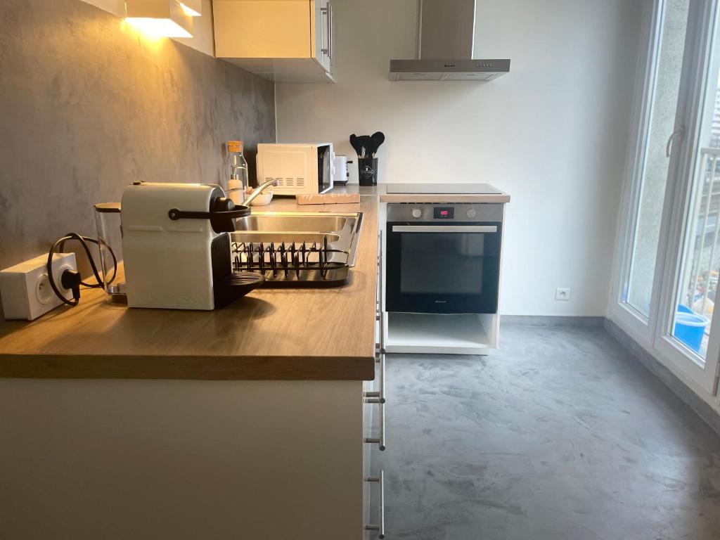 a kitchen with a counter top with a sewing machine at Appartement confortable aux portes de Paris in Charenton-le-Pont