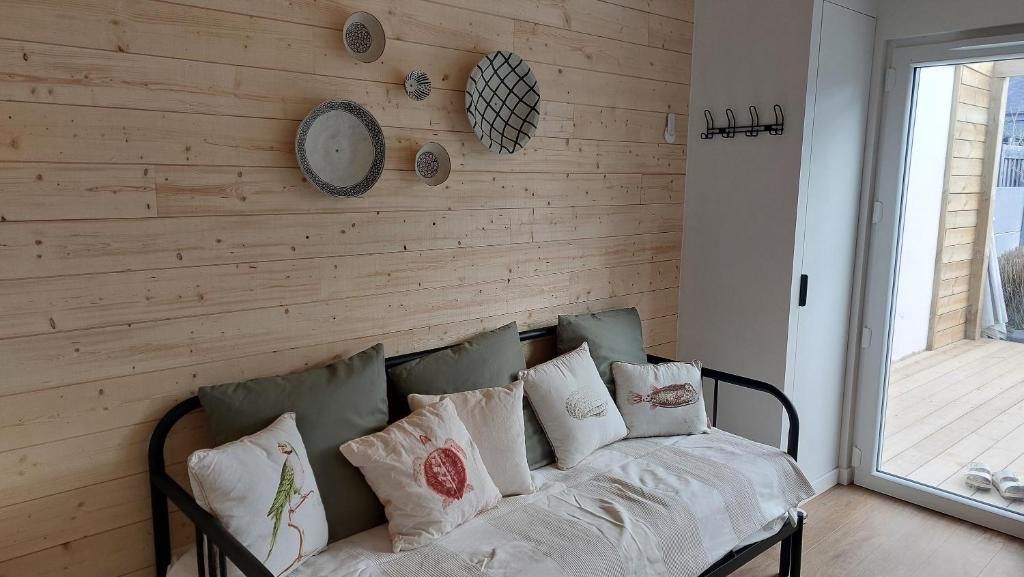 - un canapé dans une chambre dotée d'un mur en bois dans l'établissement La Dune de Sable Les Evens, à Pornichet
