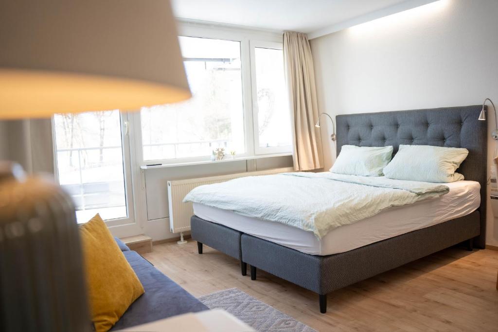 a bedroom with a bed with a large window at Bavarian Escape Ferienwohnung mit Pool in Sankt Englmar