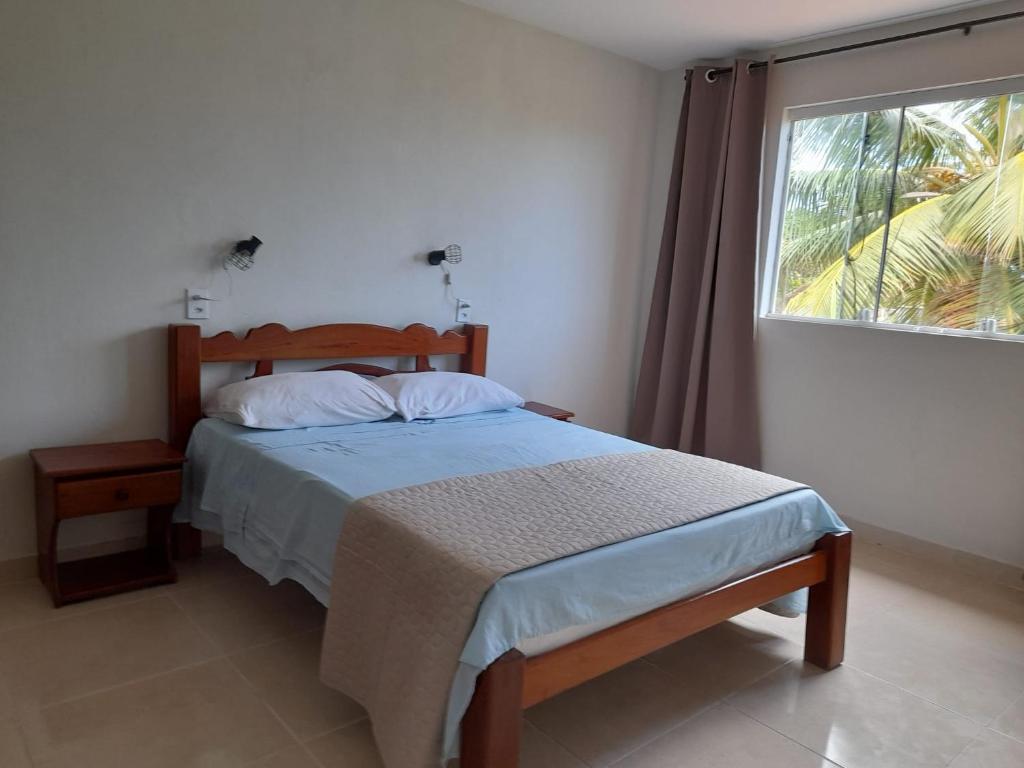a bedroom with a bed and a large window at Casa Mar Azul in São José da Coroa Grande