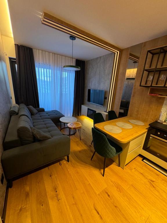 un soggiorno con divano e tavolo di Apartman Winter Park a Bjelašnica
