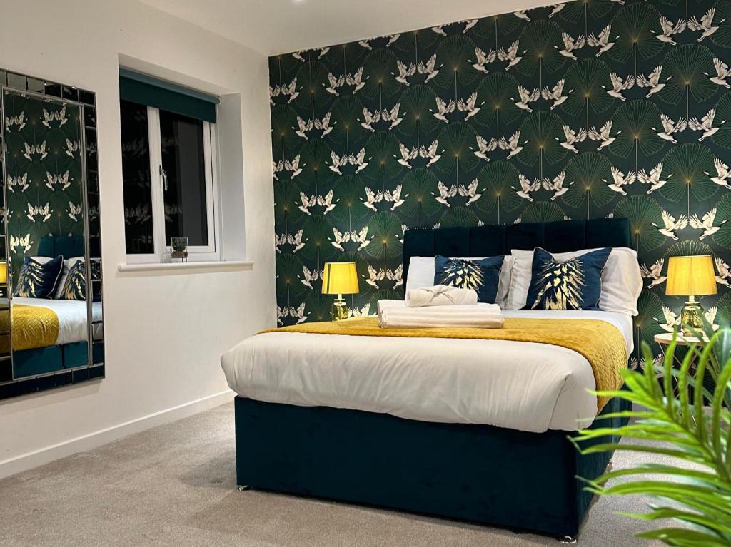 1 dormitorio con 1 cama con pared verde en Fort House 6 Large Private Bedrooms with 7 beds, close to NEC, JLR, City Centre, en Birmingham