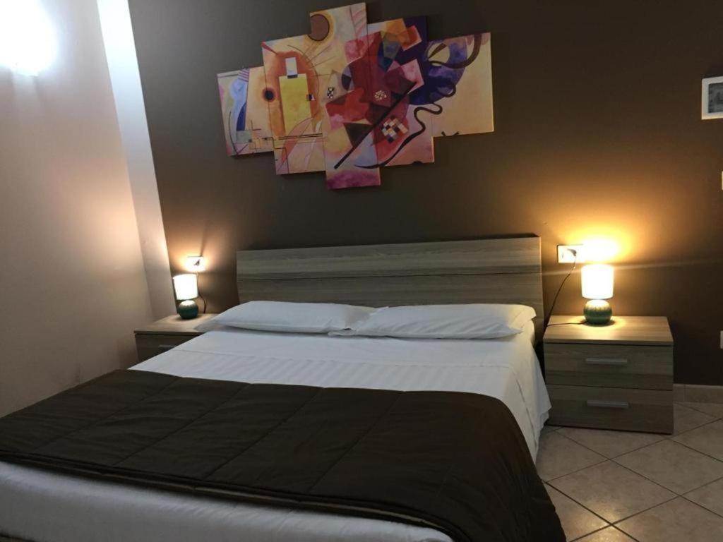 sypialnia z łóżkiem i obrazem na ścianie w obiekcie camera b&b w mieście Parma