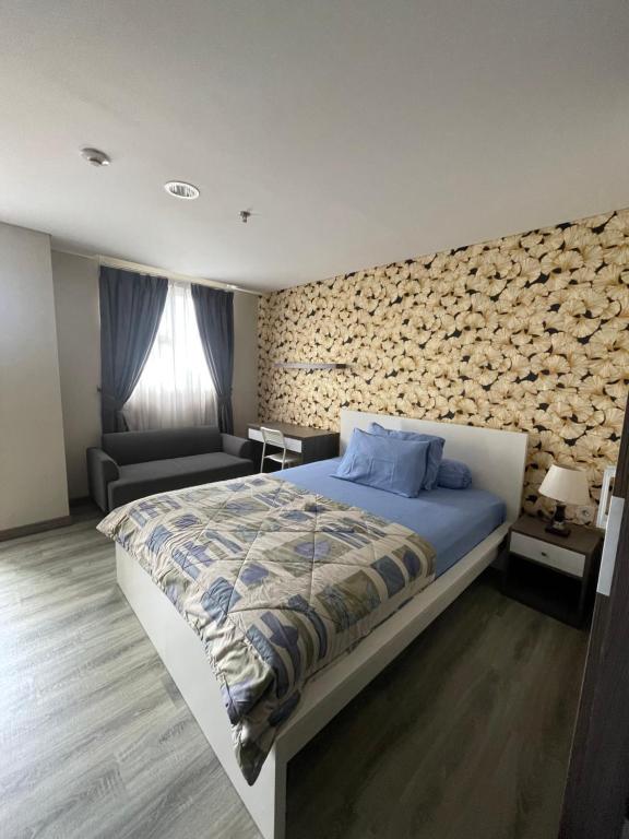 a bedroom with a bed and a stone wall at ICON ROOMS in Pondokaren