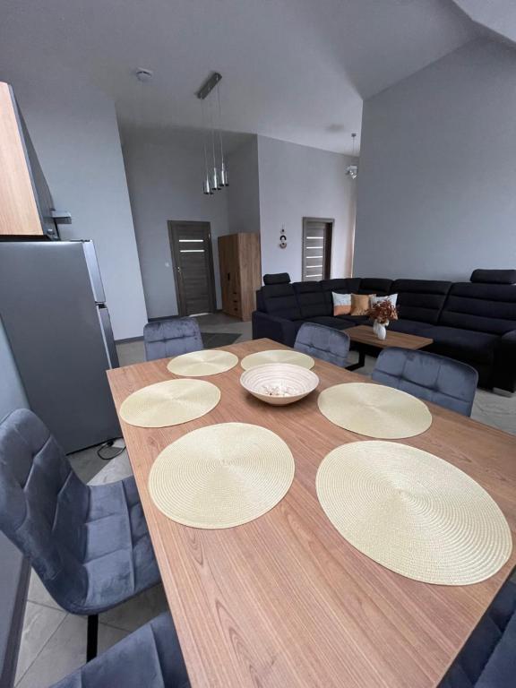 una sala de estar con una mesa de madera con platos. en Apartamenty Świerkowa #1, en Ząbkowice Śląskie