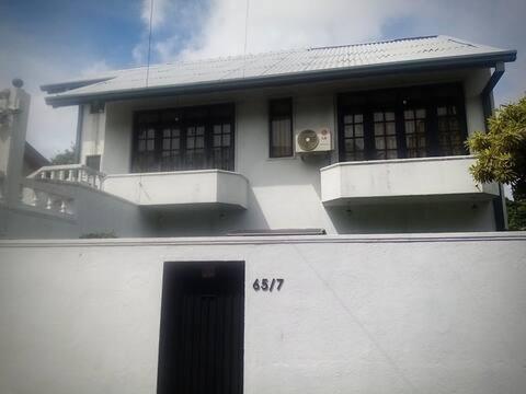 a white house with a black door in front of it at Mirihana Residence in Nugegoda