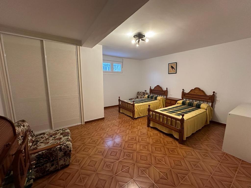 ein Zimmer mit 2 Betten und einem Sofa darin in der Unterkunft Casa Kiros in Cangas
