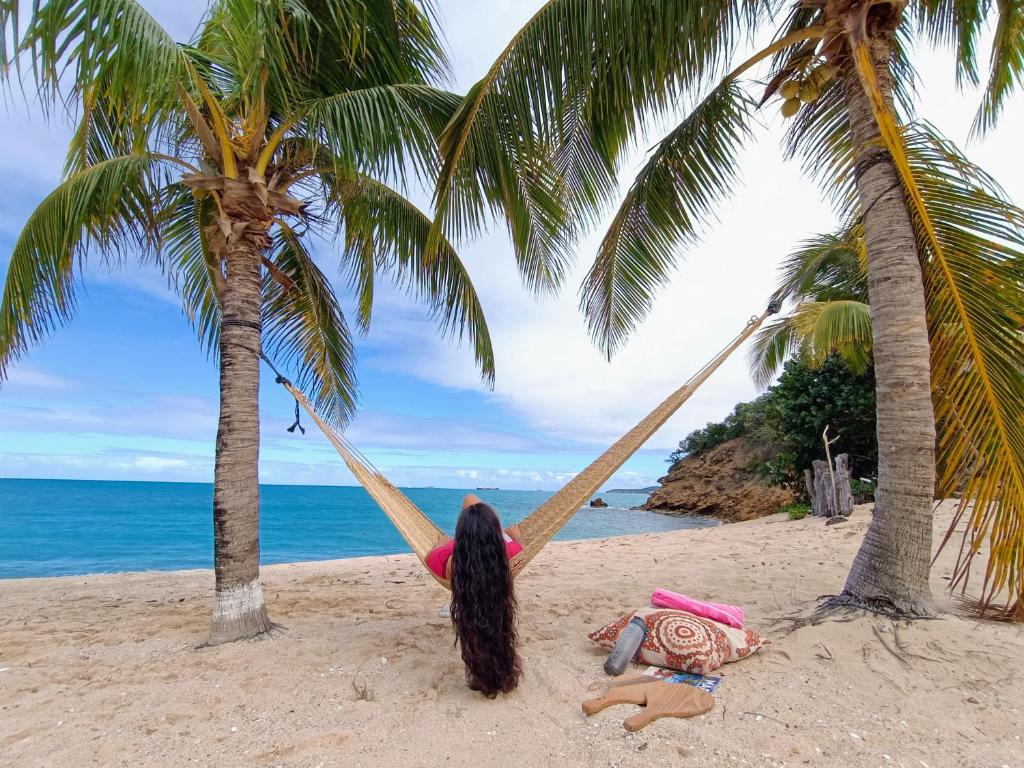 a girl laying on a hammock on a beach at Comfy house on a hidden beach in Five Islands Village