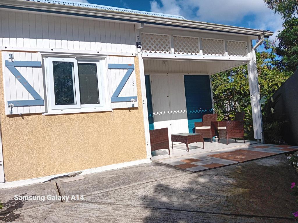 Cette maison dispose d'une terrasse couverte avec des chaises et une table. dans l'établissement gîte La Cannaie, à Port-Louis