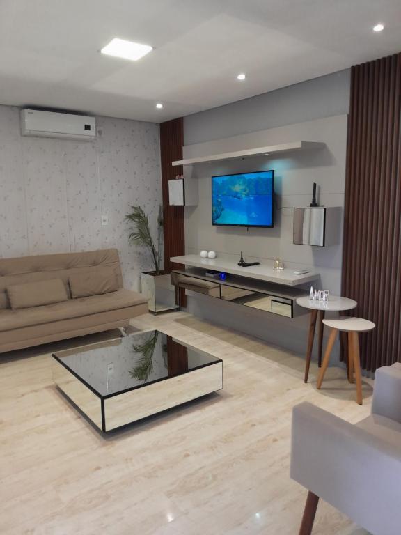 uma sala de estar com um sofá e uma televisão em CASA NO BORGO MOBILIADA em Bento Gonçalves