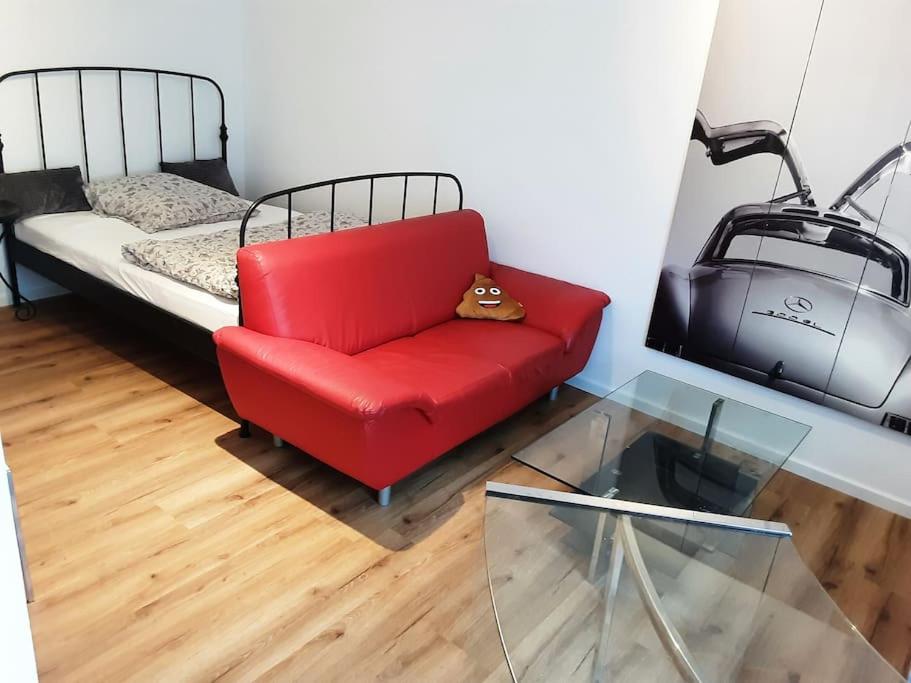 Una sala de estar con un sofá rojo y una cama. en Alfred First, en Regensburg