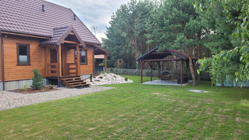 a log cabin with a gazebo in a yard at Domek przy Polnej Drodze in Langendorf