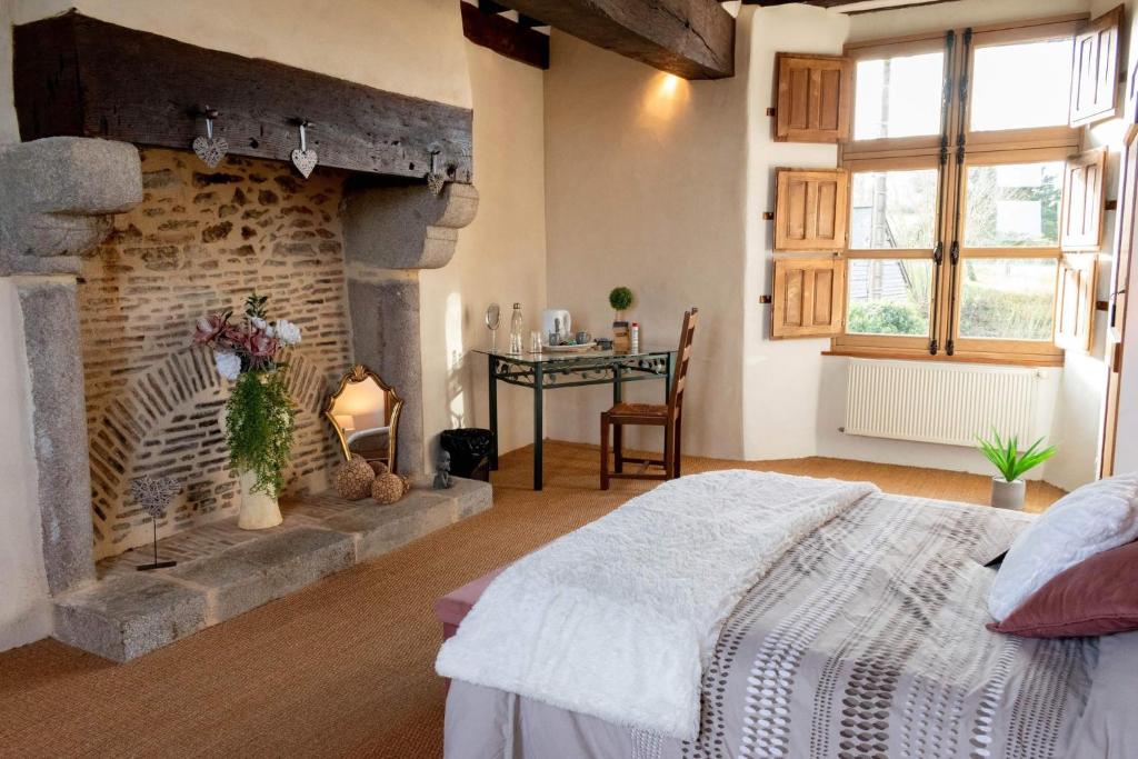 a bedroom with a fireplace and a bed in a room at Manoir de la coudre in Changé