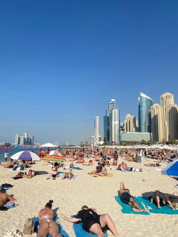 un gruppo di persone sdraiate sulla sabbia sulla spiaggia di The Comfort Stay a Dubai