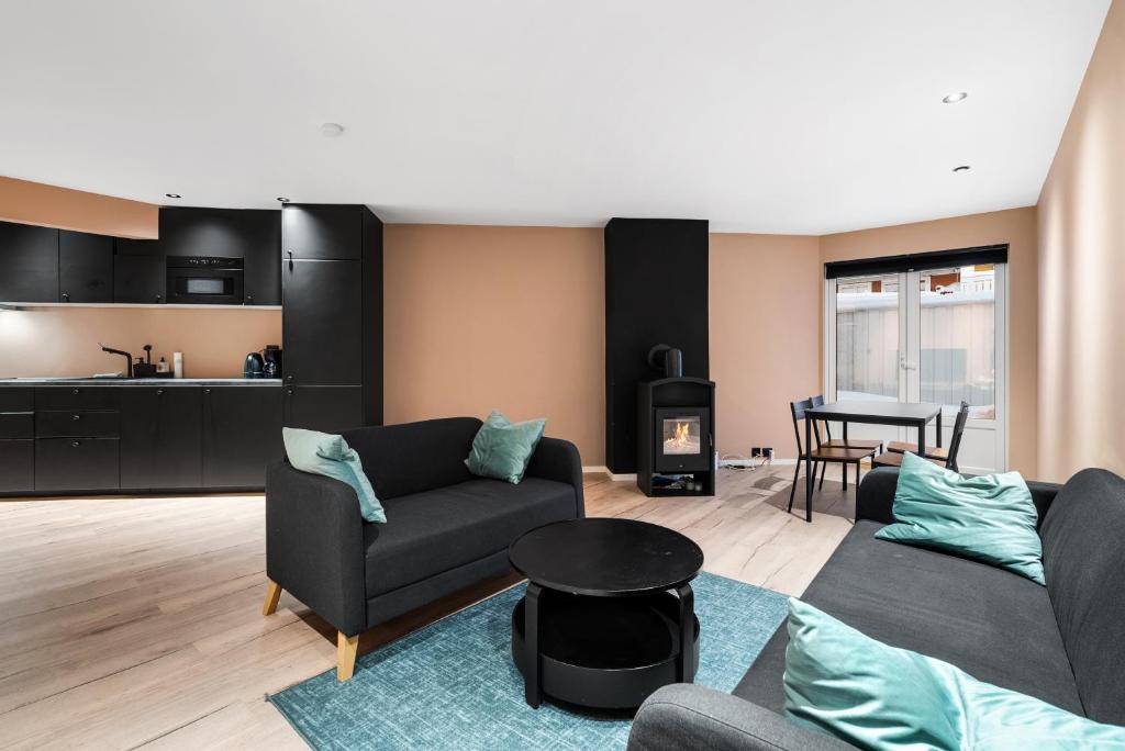 a living room with two couches and a stove at Cozy new apartment in Kristiansand