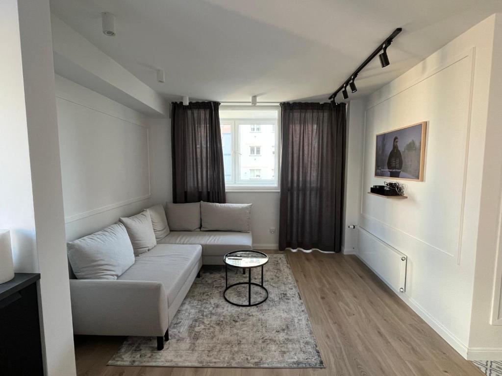 sala de estar con sofá blanco y mesa en Modern Apartament Gdynia, en Gdynia