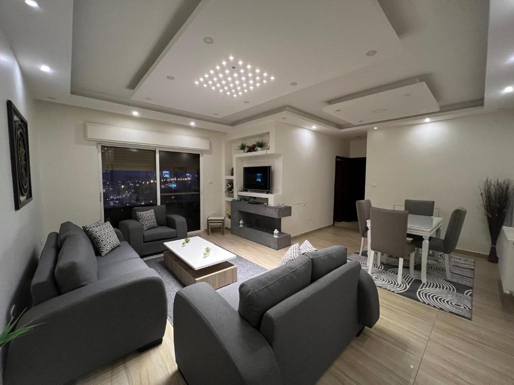 a living room with couches and a dining room at Prime apartment with amazing view in Amman in Amman