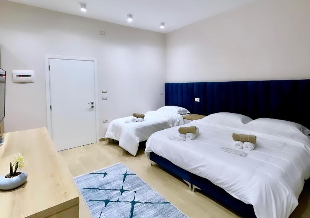 Habitación de hotel con 2 camas y mesa en Hotel Krial en Berat