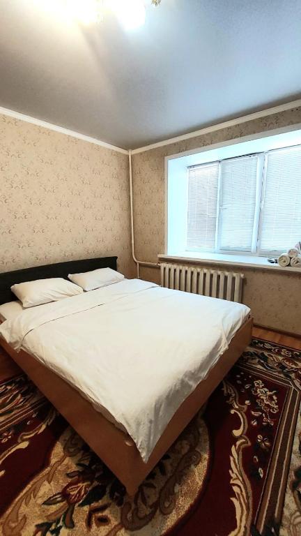 1 cama grande en un dormitorio con ventana en Аэропорт Астана 5 минут юг1 582 en Prigorodnyy