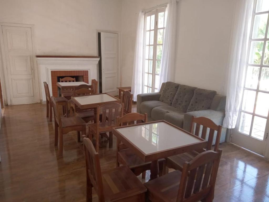 sala de estar con mesas, sillas y sofá en Pousada Inaya, en Petrópolis